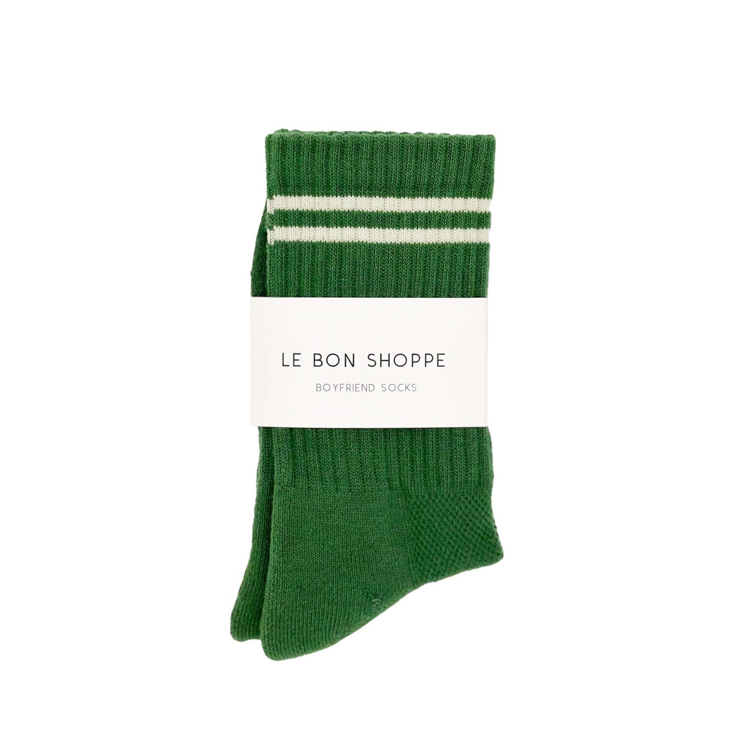 A pair of green moss ribbed crew socks with white stripes near the cuff, neatly folded and wrapped with a white Le Bon Shoppe label, placed on a white fabric background.