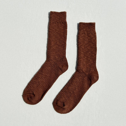 Pair of brown socks on a light gray background