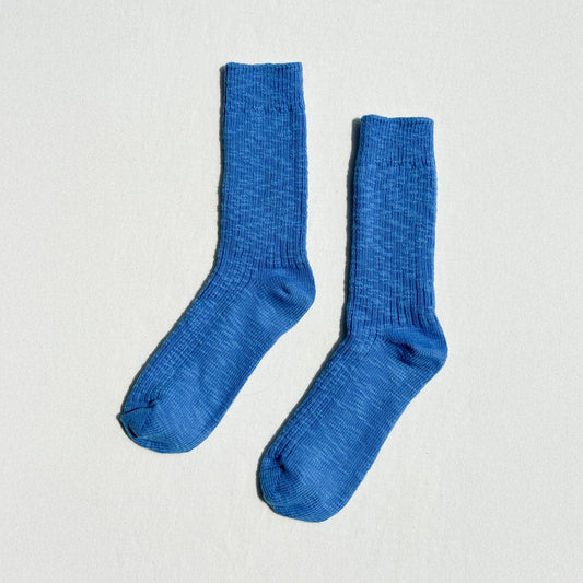 Pair of blue socks on a light gray background