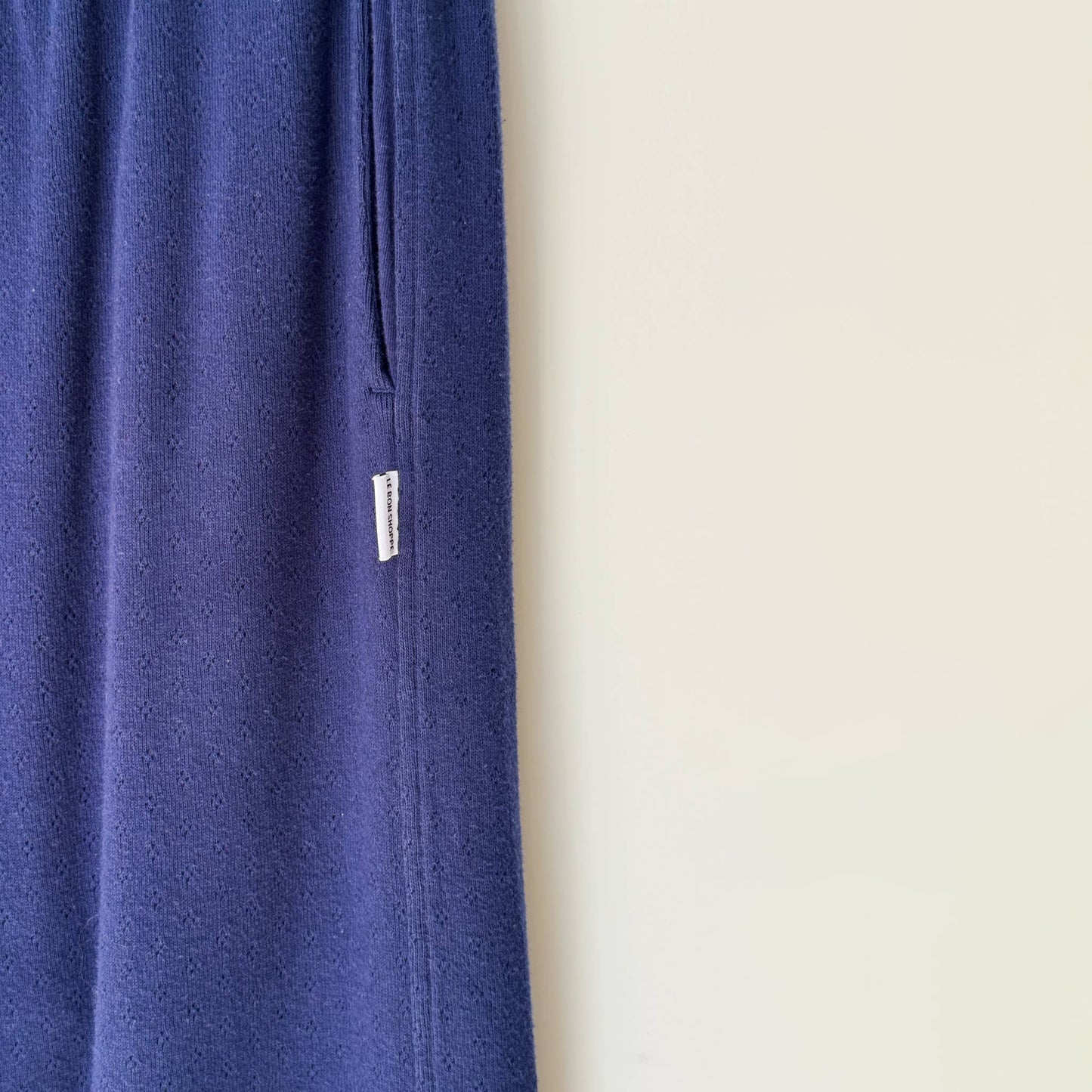 Blue pant leg with a small white label on a beige background