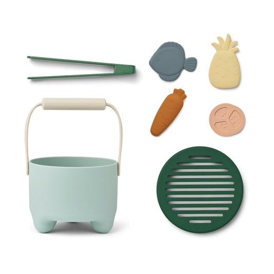 Children's play set with a mint green pail, tongs, and various silicone food-shaped molds on a white background.