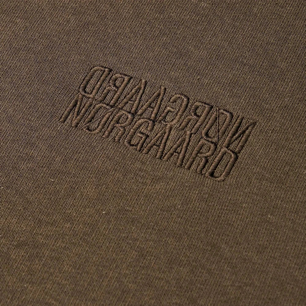 Brown fabric with embroidered text 'NORGAARD NORGAAARD' on a brown background