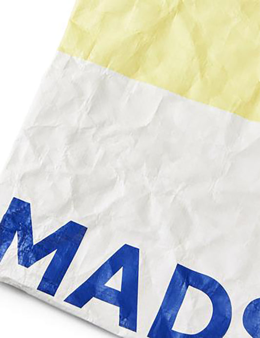 Close-up of a yellow and white fabric with blue text on a white background