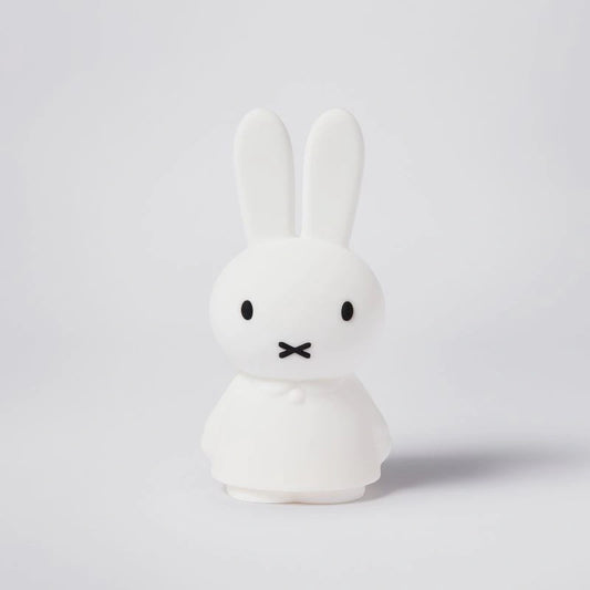 A wireless, rechargeable LED lamp featuring the iconic Miffy design in a white color, with a soft silicone body and a gentle light, displaying a 4-step dimming feature and a one-hour timer.
