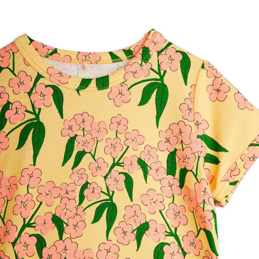 Yellow t-shirt with pink floral pattern on a white background