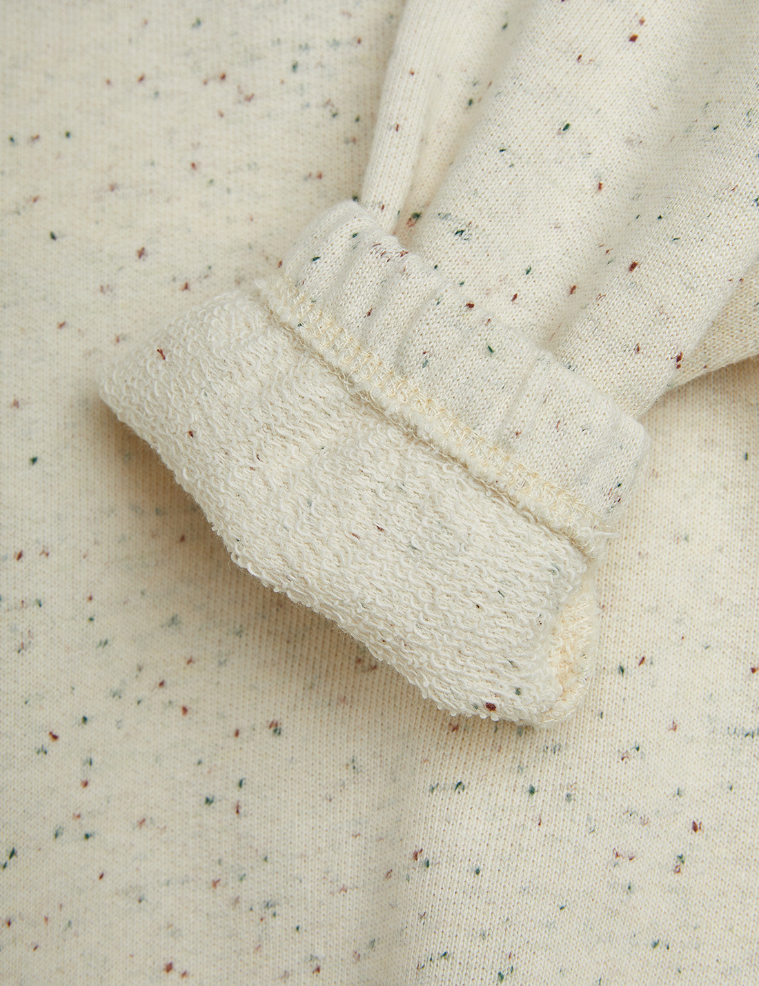 Close-up of textured fabric with a ribbed trim on a light background