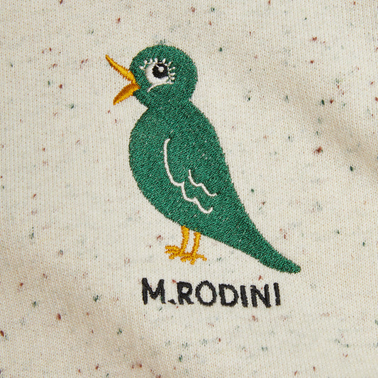 Embroidered green bird design on a textured fabric with 'M.Rodini' branding.