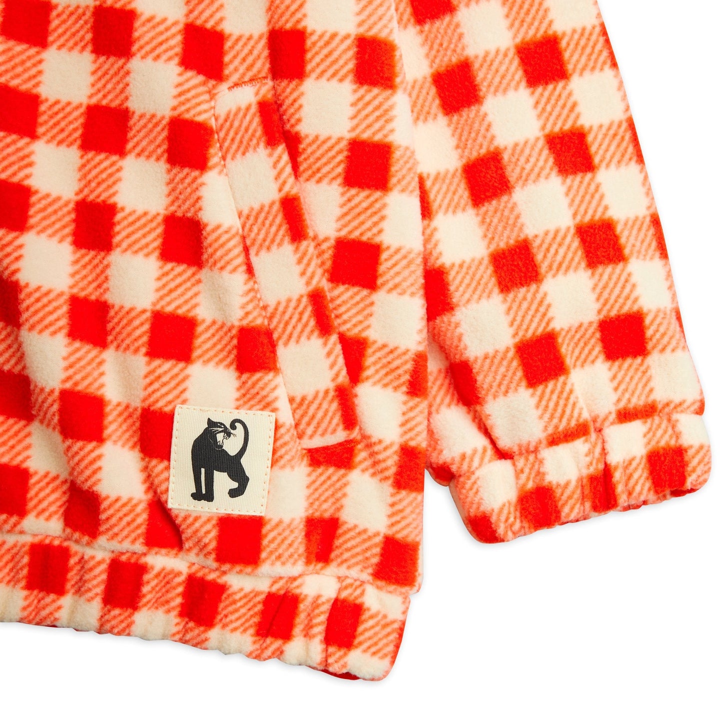 Red and white checkered fabric with a black and white label featuring a cat icon on a white background