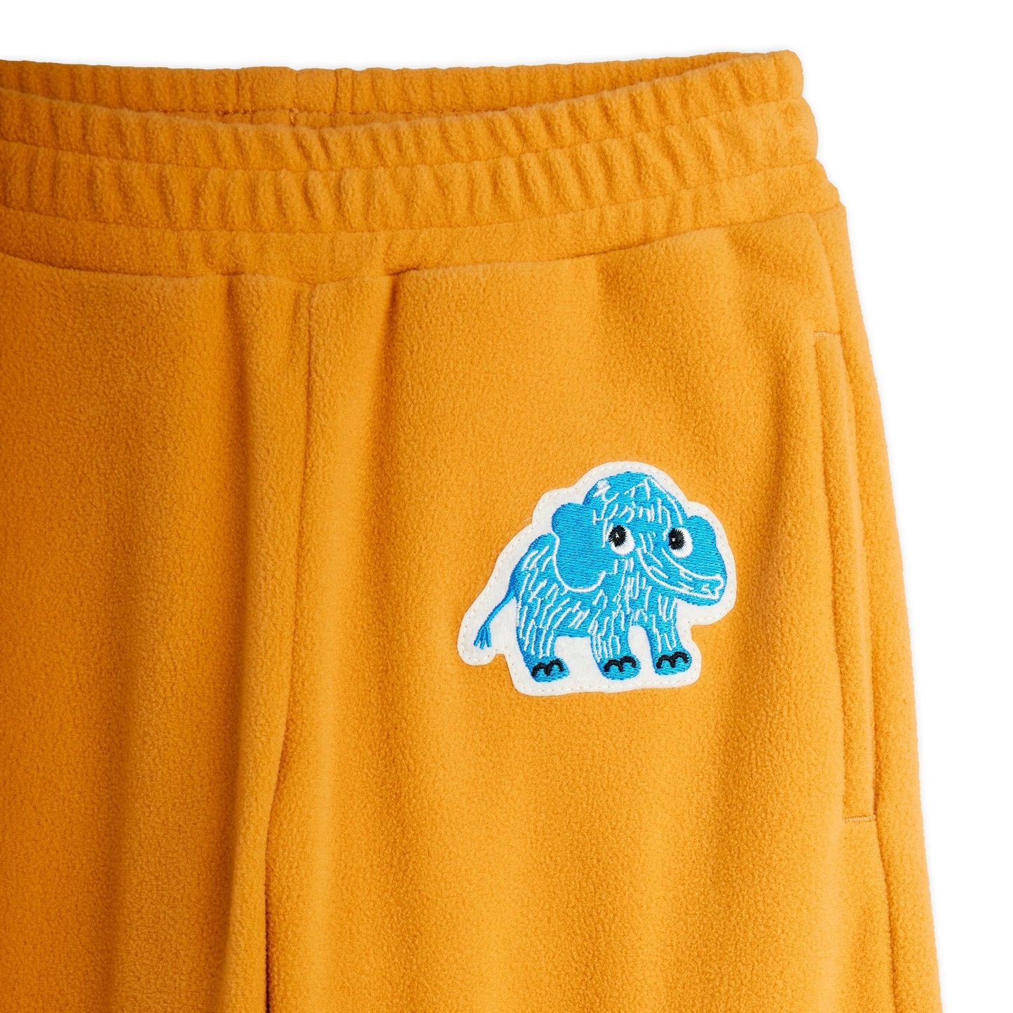 Orange sweatpants with a blue mammoth design on a white background