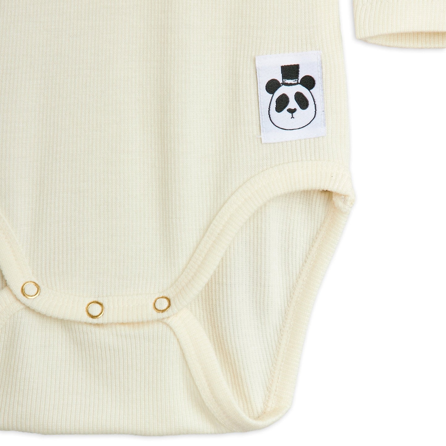 Close-up of a cream-colored baby bodysuit with a panda logo tag on a white background