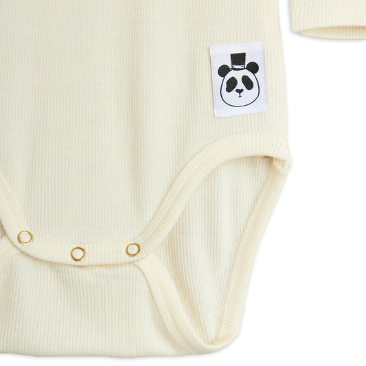 Close-up of a cream-colored baby bodysuit with a panda logo tag on a white background
