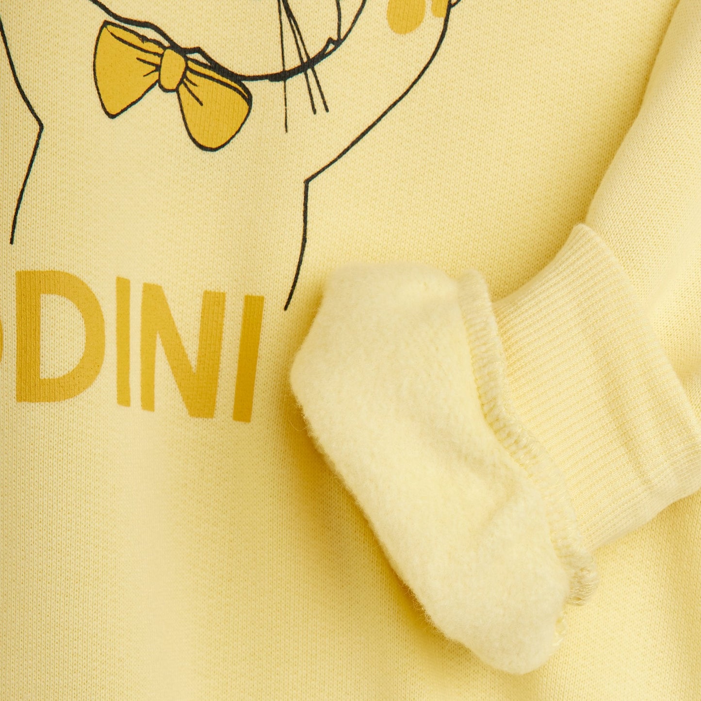 Yellow outfit with a cartoon character and branding on a yellow background