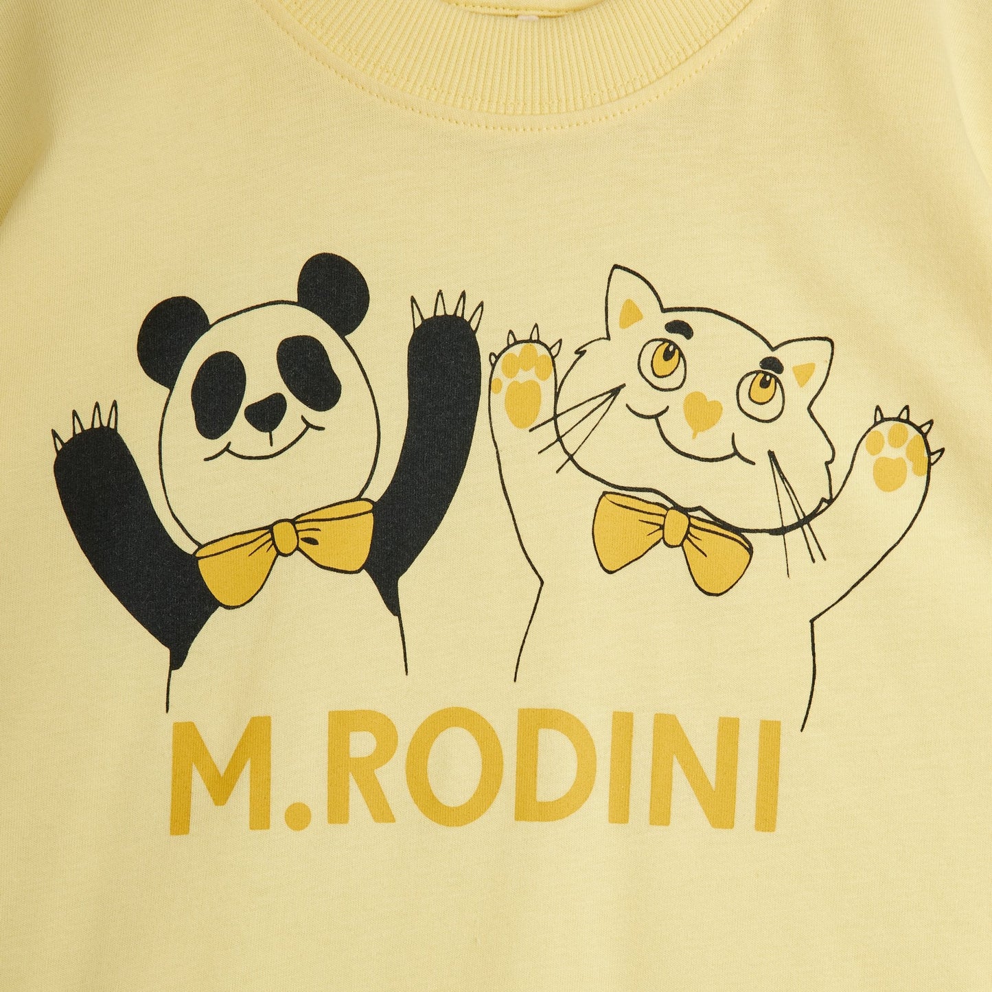 Yellow shirt with panda and cat illustration and 'M. Rodini' branding