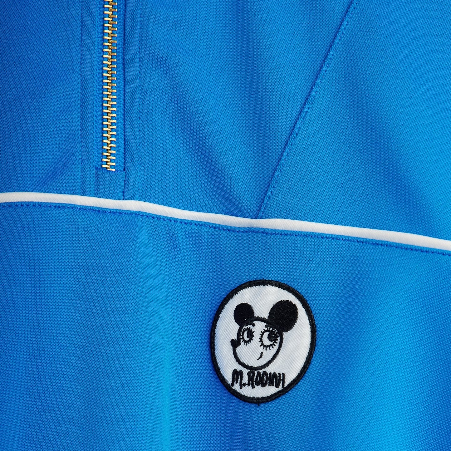 Blue jacket with a patch featuring a cartoon character and text on a blue background