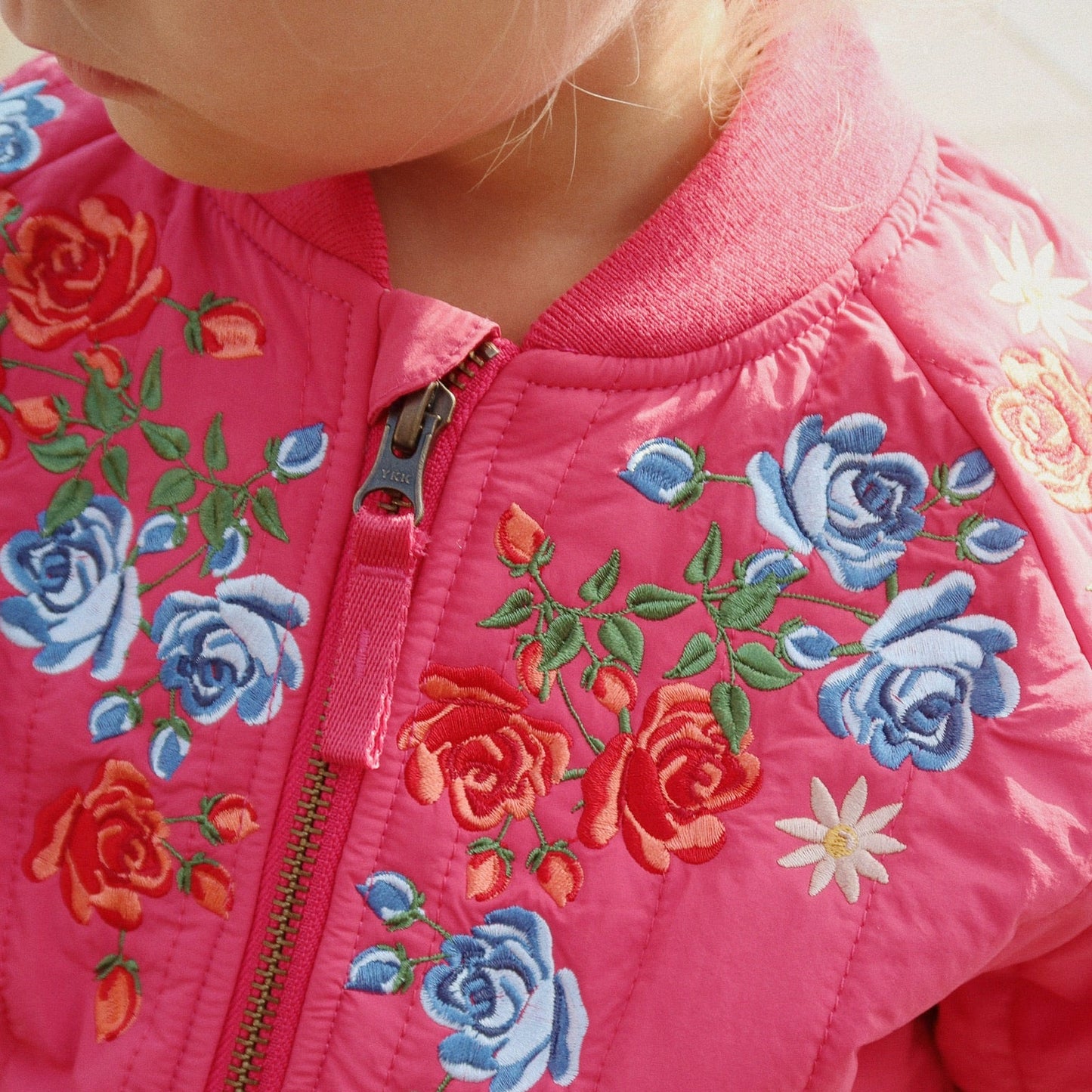Close-up of a pink jacket with floral embroidery