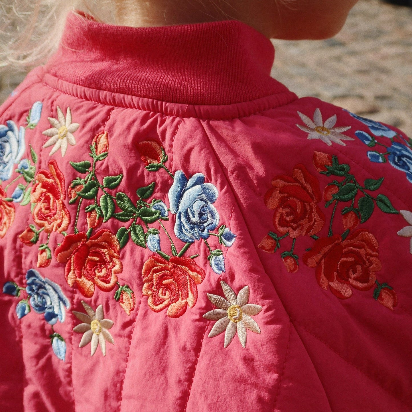 Close-up of a pink garment with floral embroidery