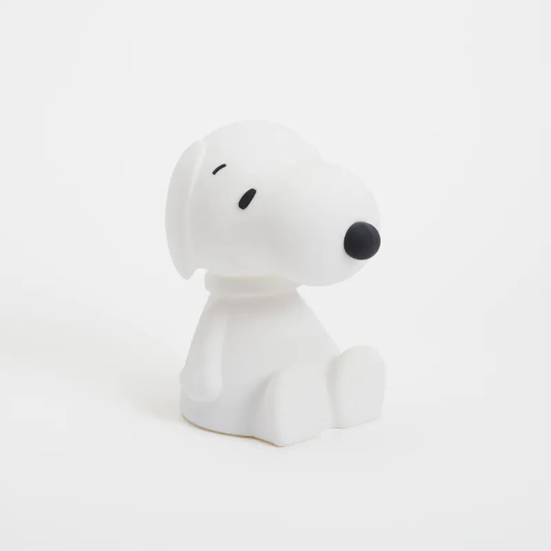 A white Snoopy-shaped lamp emitting a soft light, sitting against a plain background.