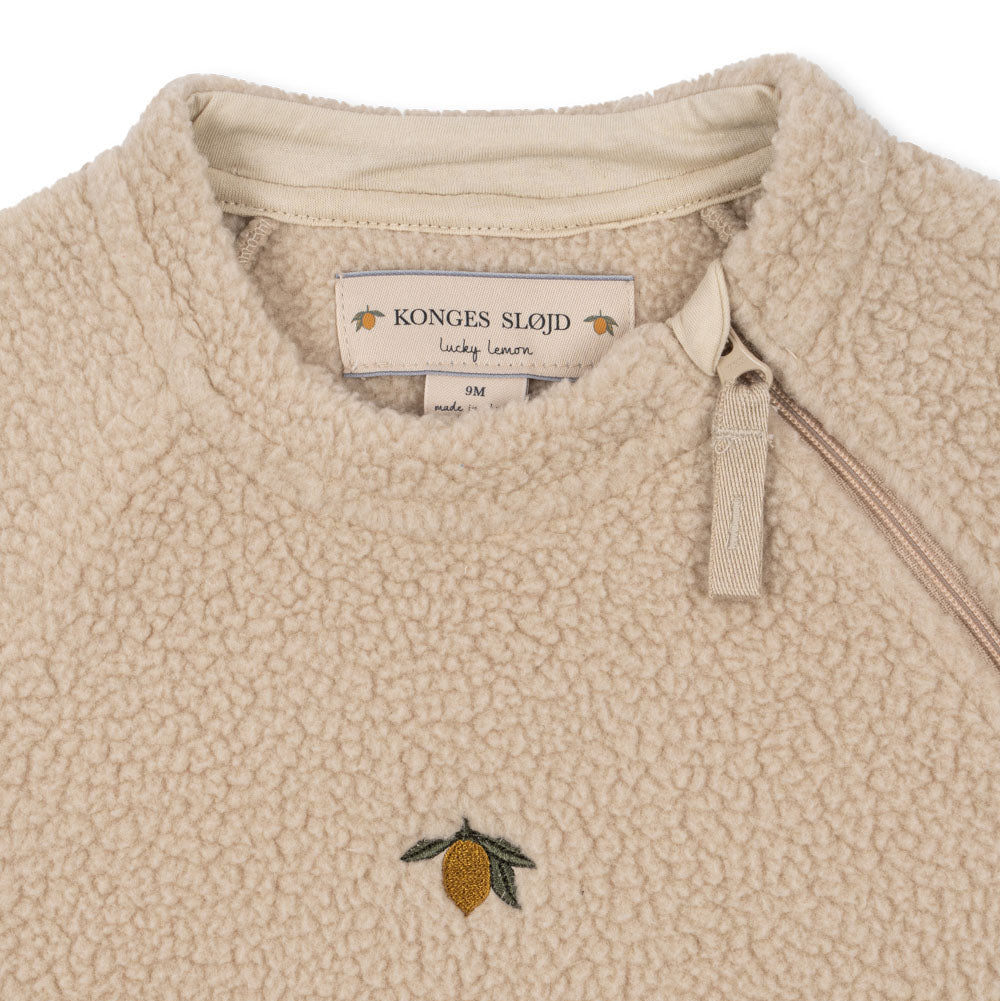 Beige fleece jacket with a lemon embroidered logo and Konges Slojd label.