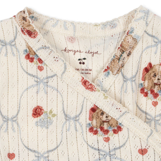 Textile with teddy bear and heart pattern and Konges Slojd branding.