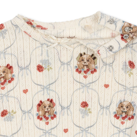 Patterned fabric with dog and rose design on a white background