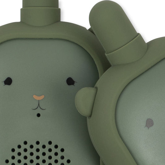 Green animal-shaped speaker with a face on a white background
