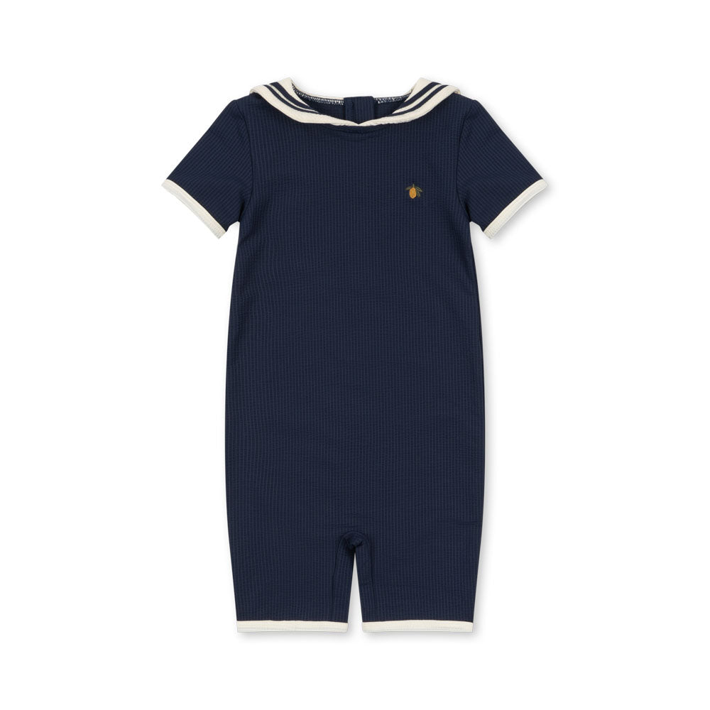 Navy blue retro swimsuit with white trim on a white background