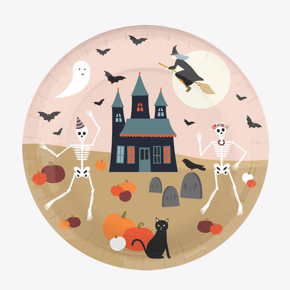 A paper plate with a Halloween theme, featuring a witch, bats, a pumpkin, and a spooky house.