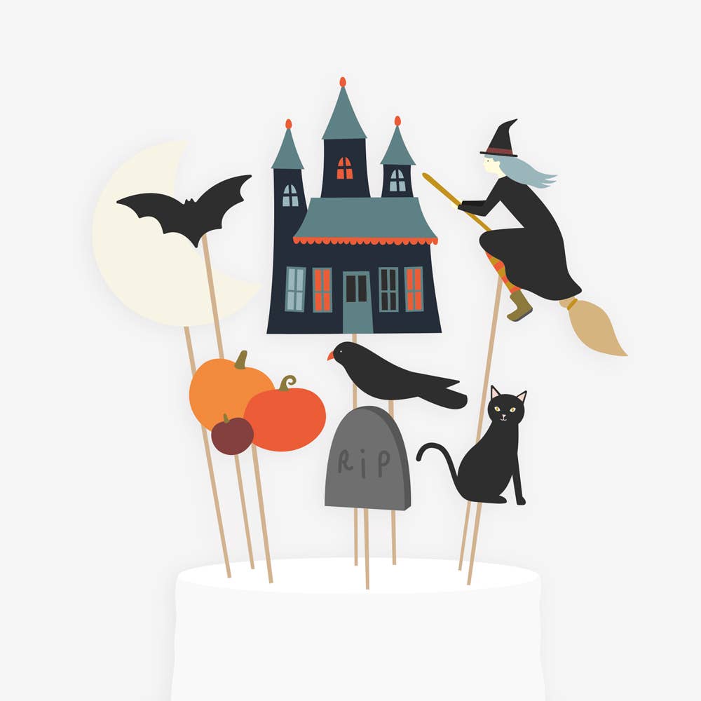 A set of Halloween-themed cake toppers including a witch, a bat, a pumpkin, a black cat, a gravestone, and a haunted house.