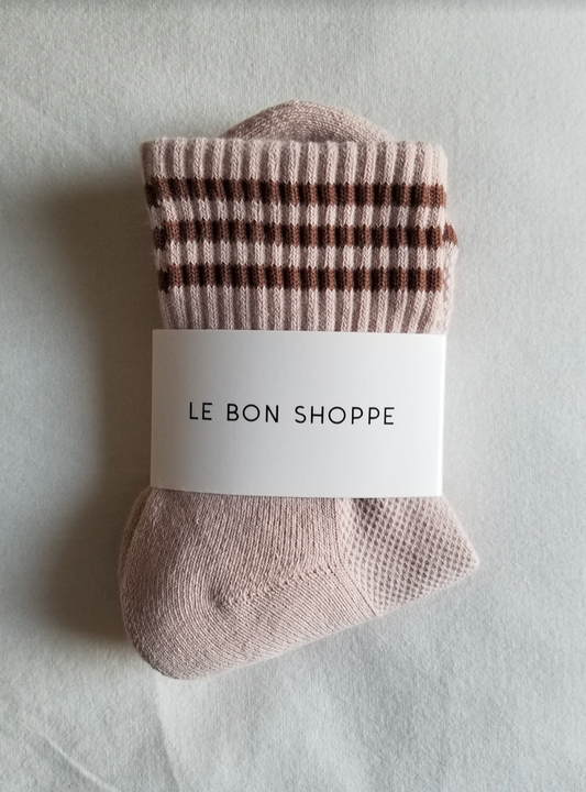 A pair of Bellini pink ribbed crew socks with brown multi-stripe details, neatly folded and wrapped with a white Le Bon Shoppe label, placed on a white fabric background.
