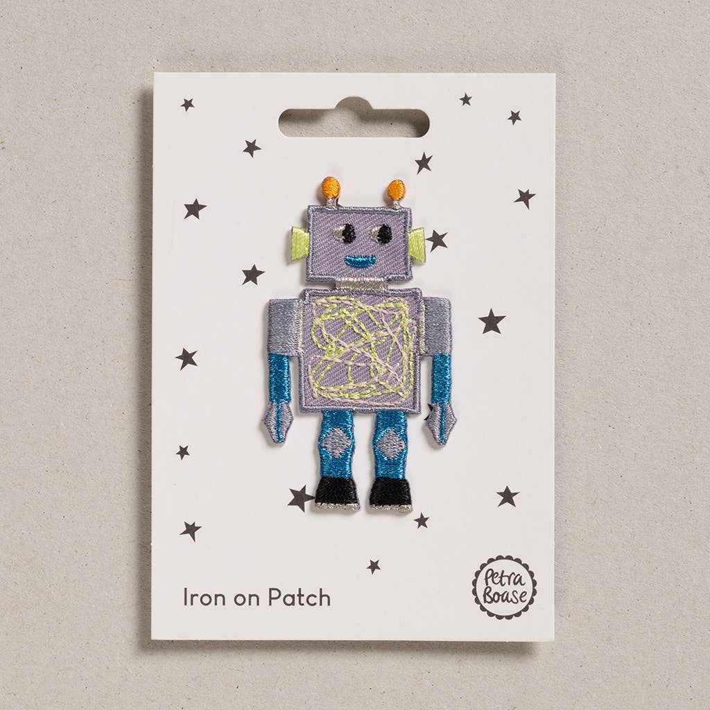 an embroidered robot who is grey in colour with blue hand and legs. His eyes and feet are black. His ears are lime green in colour and his mouth is blue. His body has green lines on it. The background is white with black stars