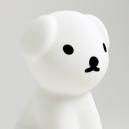 Close up of the Snuffy First Light Lamp, a silicone dog shaped night light with simple black line design for the face.