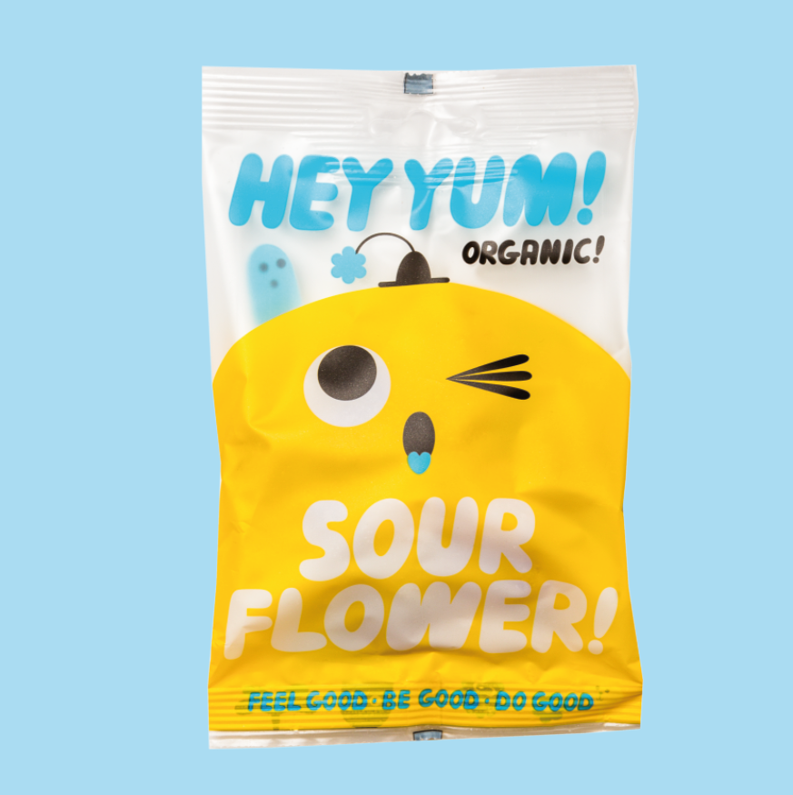 Packaging of HEY YUM! Organic Sour Fruit Gums, featuring a cartoon bird character on a yellow background with the text 'SOUR FLOWER' prominently displayed.