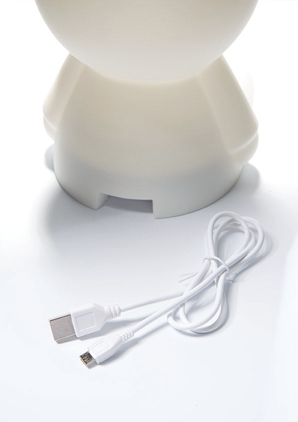 The rear view of the Miffy First Light Lamp, shaped like a rabbit on a white background. The USB-C type charging cable is placed on the white background near the Miffy Lamp