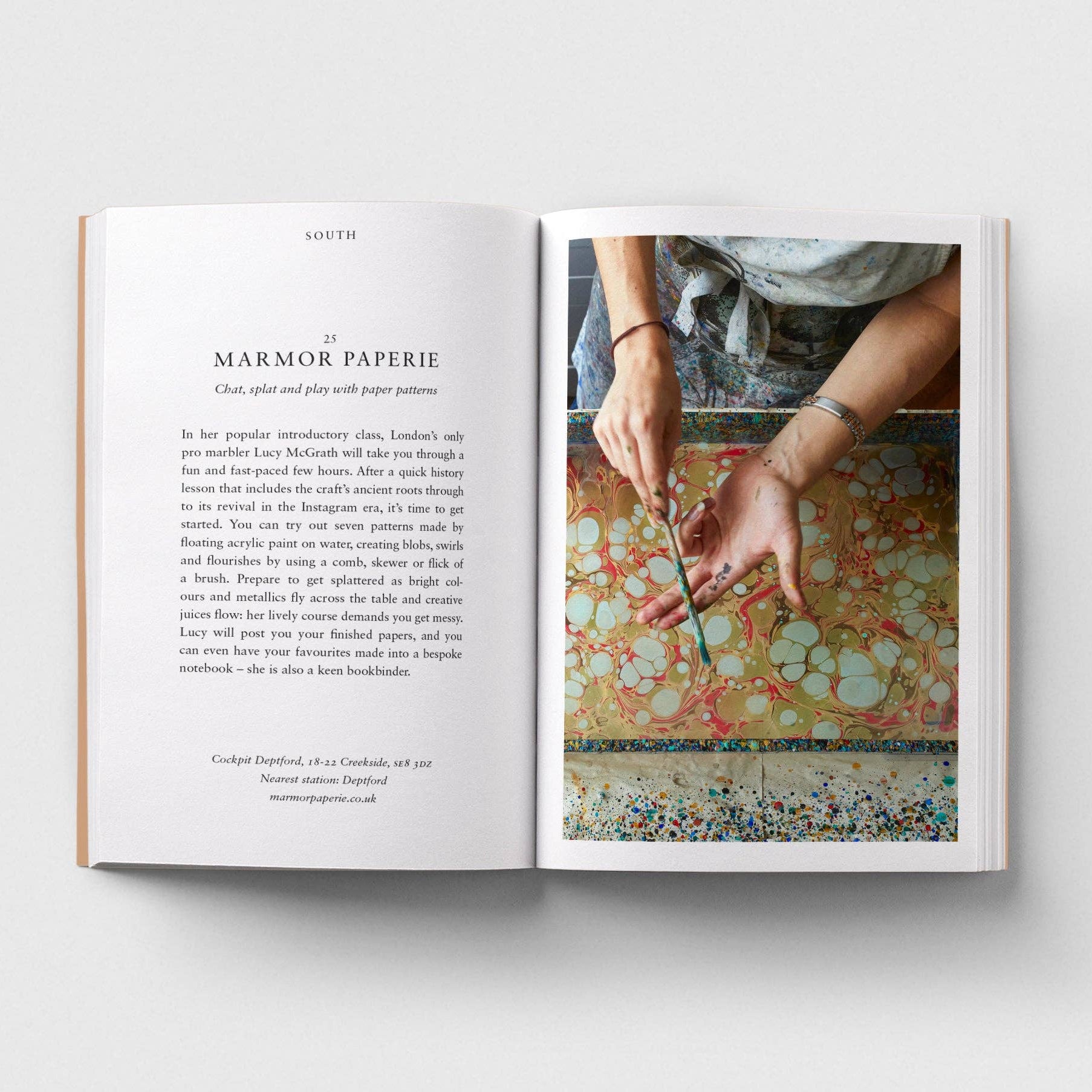 Open book showing a page with text and an image of hands working with paper.