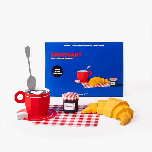 Croissant packaging with a red mug, jar of jam, and croissant on a white background