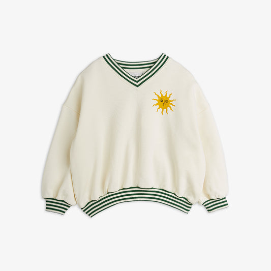 White sweater with green stripes and a sun design on a white background