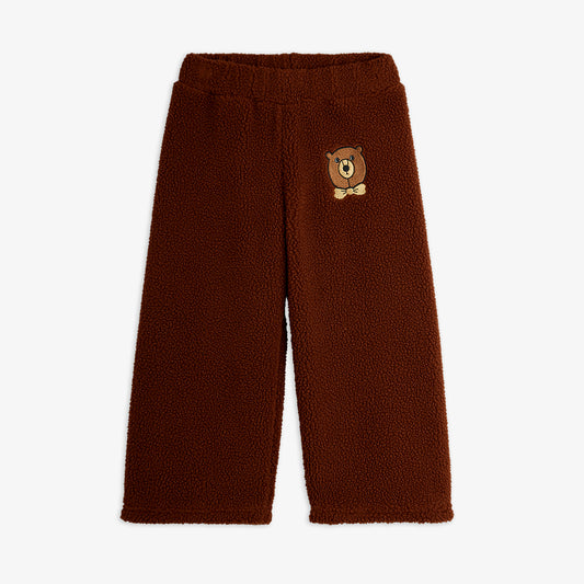 Brown fleece pants with a bear patch on a white background