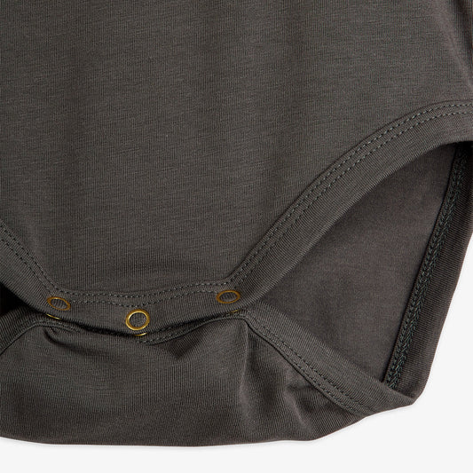 Close-up of a dark gray baby bodysuit on a white background