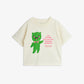 Beige t-shirt with a green character and text on a white background
