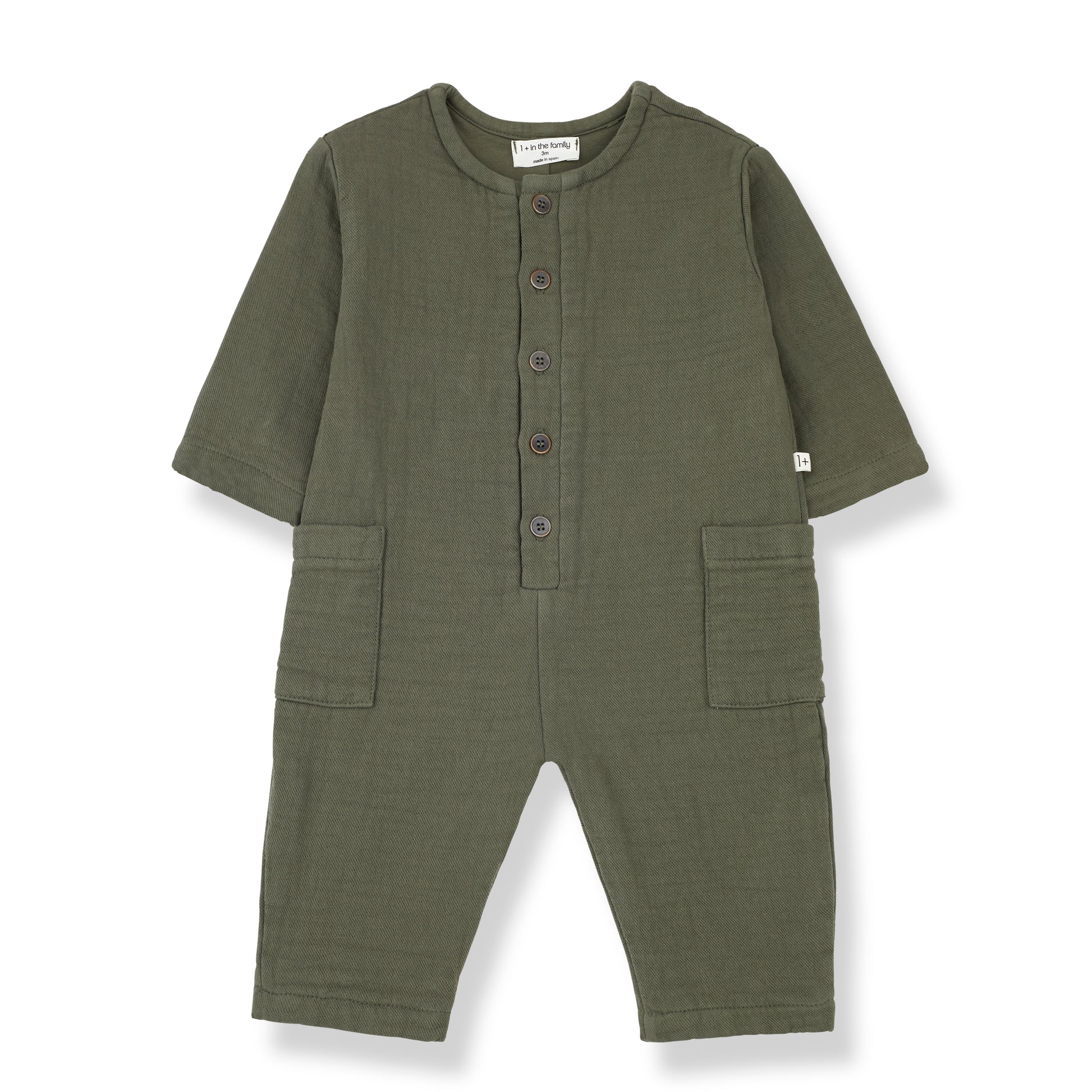 a green jumpsuit with open sleeve ends and trousers, with two square pockets on the sides and a button up front with 5 buttons to a round neckline