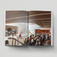 Open book showing an interior view of a concert hall with people in attendance.