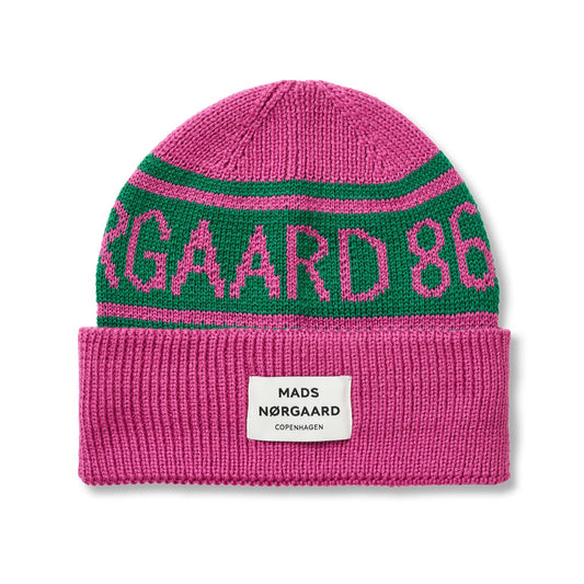 Pink and green beanie with 'Mads Nørgaard 86' branding on a white background