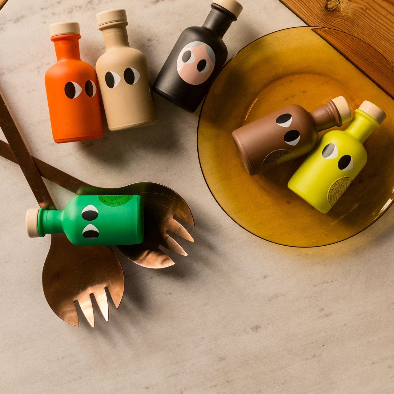 Colorful bottle-shaped cutlery set on a wooden surface