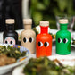 Four colorful bottles with face-like designs on a table with food.