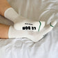 White socks with text on a white bed
