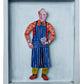 Framed artwork of a person wearing a colorful outfit with a blue apron.