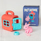 Toy pet house with pink rabbit figure and packaging on a textured surface