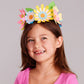 Young girl wearing a colorful flower crown against a gray background