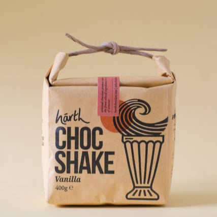 Kraft paper packaging of a vanilla chocolate shake with a handle on a beige background