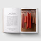 Open book with text on one page and a photograph of red candles on the other, on a white background.